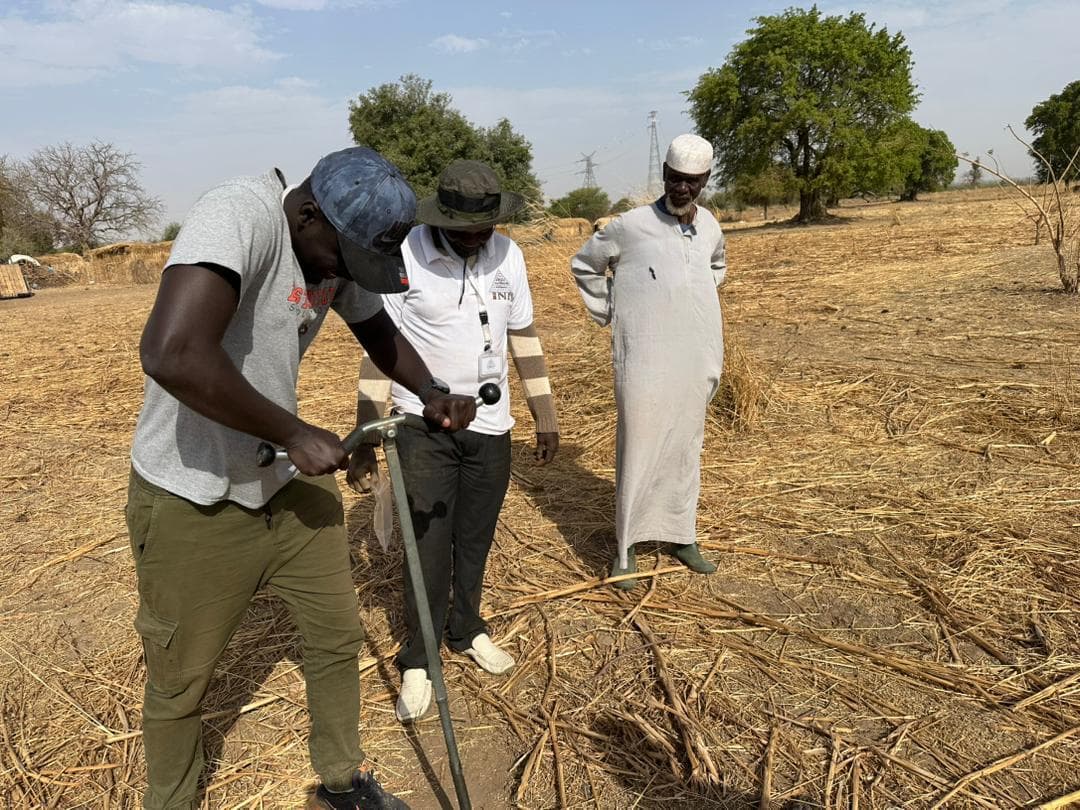Agent de l'INP réalisant un prélèvement de sol à la tarière en milieu rural